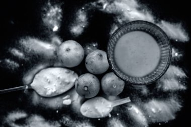 Kabartma tozu yüz maskesi ahşap yüzeyüzerinde cam bir kapta bazı kabartma tozu ile birlikte yüzeye serpilir ve limon da yüzeyde. Deriyi anında lekeler. Yatay üst atış.