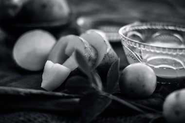 Bazı limon suyu, patates suyu ve bal ile birlikte kahverengi renkli yüzeyüzerinde bir cam kase patates suyu Parlayan yüz maskesi. Yatay atış.