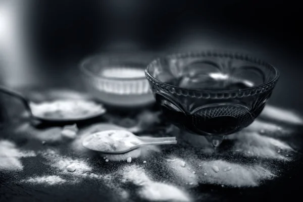 Baking soda face mask in a glass bowl on wooden surface along with baking soda powder and honey for Dark lips.Horizontal shot.