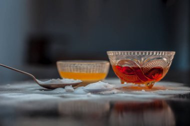 Kabartma tozu tozu ve Koyu dudaklar için bal ile birlikte ahşap yüzeyüzerinde bir cam kase de kabartma tozu yüz maskesi pişirme. Yatay atış.