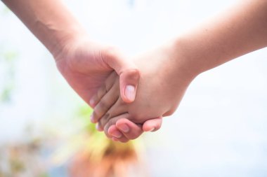 Kadın çocuğun elini tutarak yaşlı erkek bokeh arka plan ve yatay ile vurdu. Babalar Günü Kavramı ( 16 Haziran).