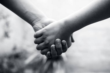 Kadın el erkek elini tutarak korkularını ve engelleri fethetmek için çalışıyor. Babalar Günü ve Kadınlar Günü kavramı. Bokeh arka plan ile yatay çekim. Yaşlının pençesini kaybetmek.