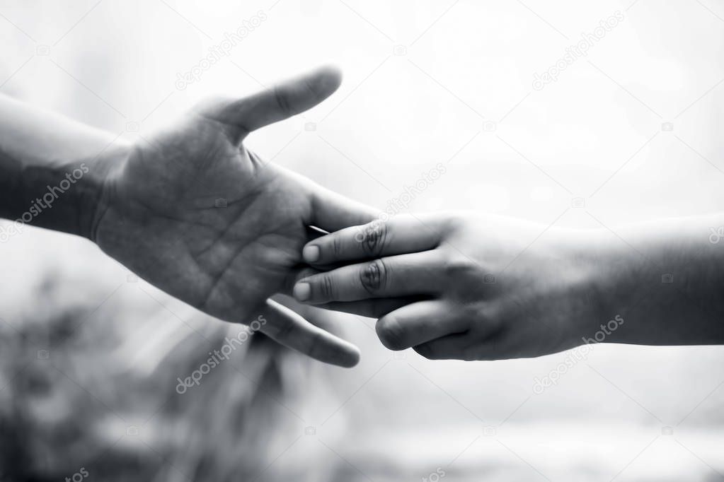 Female child's hand holding the hand of elder male shot with bokeh background and horizontal. Concept of father's day ( 16th June). 