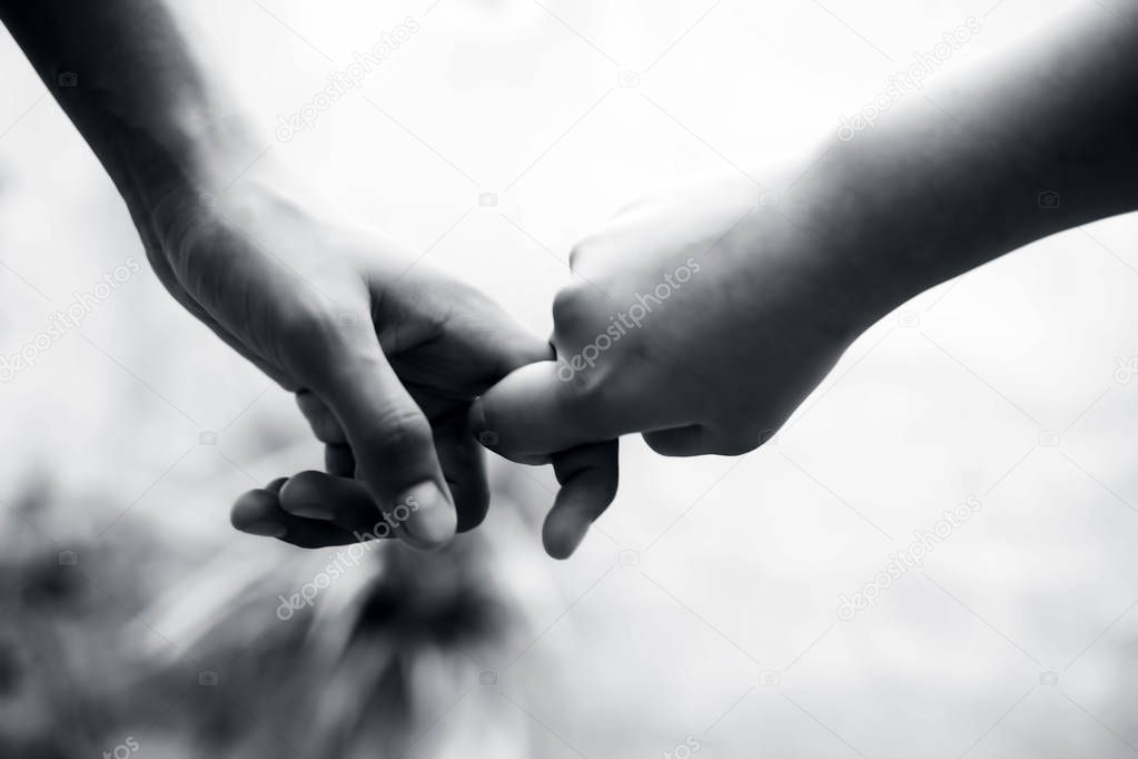 Female child's hand holding the hand of elder male shot with bokeh background and horizontal. Concept of father's day ( 16th June).