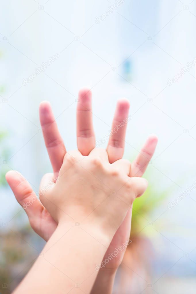 Child hand comparing her hand with her father shot with blurred bokeh background and the concept of Fathers day ( 16th June). 