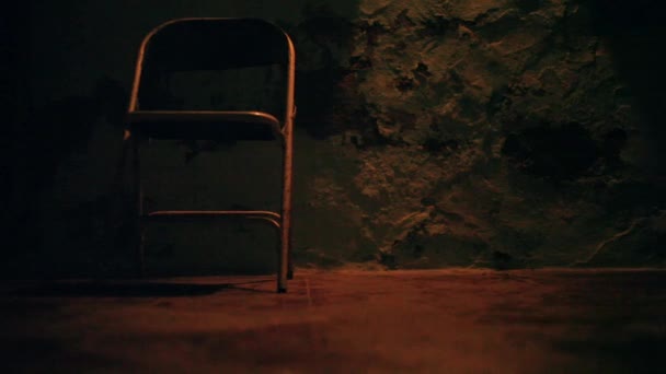 暗くて不気味で キャンドルや提灯を照らす表面上で単独で動く金属製の椅子のシルエット — ストック動画