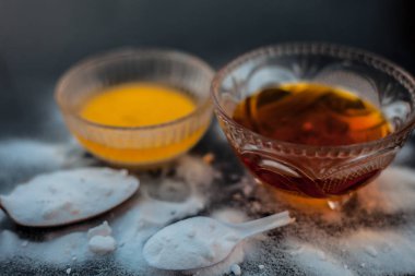 Kabartma tozu tozu ve Koyu dudaklar için bal ile birlikte ahşap yüzeyüzerinde bir cam kase de kabartma tozu yüz maskesi pişirme. Yatay atış.