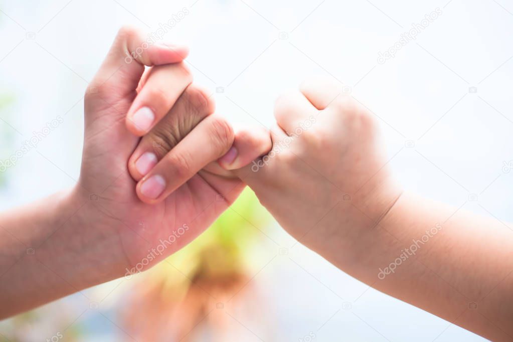 Female hand trying to conquer her fears and obstacles by holding males hand. Concept of Fathers day and womens day, Horizontal shot with bokeh background. Losing the grip of the elder.