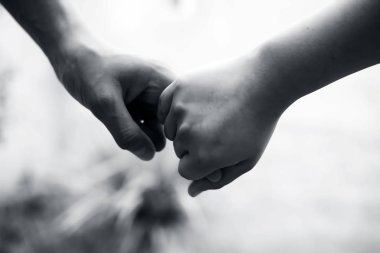 Yaşlı erkek el tutan kadın Childs el bokeh arka plan ve yatay ile vurdu. Babalar günü kavramı 16 Haziran.