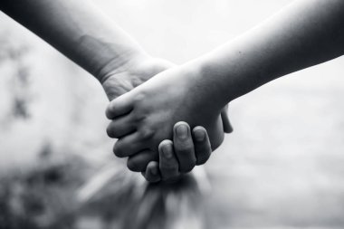 Erkek el tutarak onun korkuları ve engelleri fethetmek için çalışan kadın el, babalar günü ve Womens gün kavramı, bokeh arka plan ile yatay çekim. Yaşlı bir kavrama kaybetme.