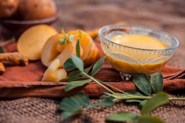 Patates yüz maskesi rendelenmiş patates ve bazı zerdeçal toz veya haldi Jüt çanta yüzeyi üzerinde bir cam kase oluşan cildi aydınlatmak için, bakteri ve mikropları öldürür.