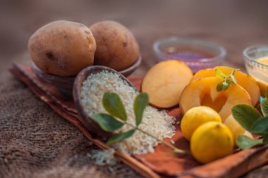 Bir cam kapta patates, limon suyu, bal ve pirinç unu oluşan jüt torbayüzeyinde pigmentasyon tedavisi için yüz maskesi. Tüm bileşenler yüzeyde. Yatay atış.