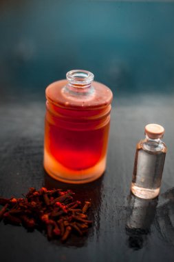 Karanfil yağı ve bazı hindistan cevizi yağı ile birlikte cam bir kase ahşap yüzeyinde akne ve sivilce karşı önleme için Karanfil yüz maskesi.