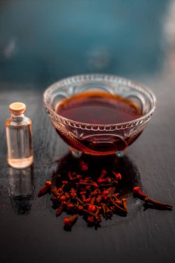 Karanfil yağı ve bazı hindistan cevizi yağı ile birlikte cam bir kase ahşap yüzeyinde akne ve sivilce karşı önleme için Karanfil yüz maskesi.