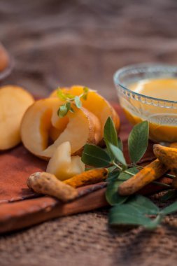 Patates yüz maskesi rendelenmiş patates ve bazı zerdeçal toz veya haldi Jüt çanta yüzeyi üzerinde bir cam kase oluşan cildi aydınlatmak için, bakteri ve mikropları öldürür.