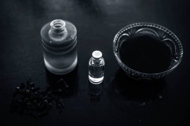 Karanfil yağı ve bazı hindistan cevizi yağı ile birlikte cam bir kase ahşap yüzeyinde akne ve sivilce karşı önleme için Karanfil yüz maskesi.