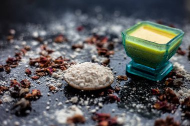 Besan veya gram un ve bazı gül suyu oluşan ahşap yüzey üzerinde cilt beyazlatma için yüz maskesi. Bazı kurutulmuş gül yaprakları ve yüzeyde gram un yayıldı. Yatay çekim.