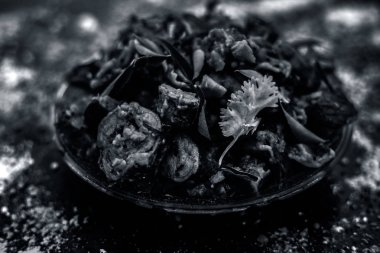 Ahşap yüzey yani Patra veya Paatra esas Colocasia esculenta veya arbi ke Pan veya fil kulak yaprakları ve baharatlar oluşan bir cam plaka ünlü Hint & Gujarati snack çanak. Yatay çekim.