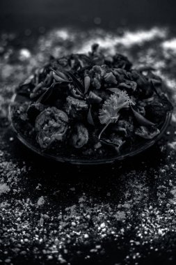 Ahşap yüzey yani Patra veya Paatra esas Colocasia esculenta veya arbi ke Pan veya fil kulak yaprakları ve baharatlar oluşan bir cam plaka ünlü Hint & Gujarati snack çanak. Dikey çekim.