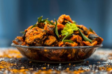 Ahşap yüzey yani Patra veya Paatra esas Colocasia esculenta veya arbi ke Pan veya fil kulak yaprakları ve baharatlar oluşan bir cam plaka ünlü Hint & Gujarati snack çanak. Yatay çekim.