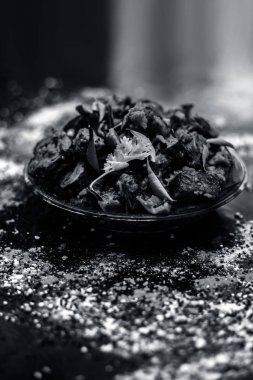 Ahşap yüzey yani Patra veya Paatra esas Colocasia esculenta veya arbi ke Pan veya fil kulak yaprakları ve baharatlar oluşan bir cam plaka ünlü Hint & Gujarati snack çanak. Dikey çekim.