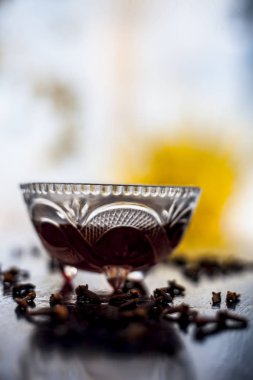 Kullanım için hazır karanfil ve petrol yüzey üzerinde bazı karanfil yayılan ile birlikte ahşap yüzey üzerinde şeffaf cam kase, yüz maskesi uygulamak.