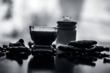 Tüm malzemeler ve yüzeyde bazı karanfil yayılmış ile birlikte ahşap yüzey üzerinde bir cam kase karanfil yağı yüz maskesi uygulamaya hazır. Akne tedavisi için.