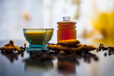 Tüm malzemeler ve yüzeyde bazı karanfil yayılmış ile birlikte ahşap yüzey üzerinde bir cam kase karanfil yağı yüz maskesi uygulamaya hazır. Akne tedavisi için.