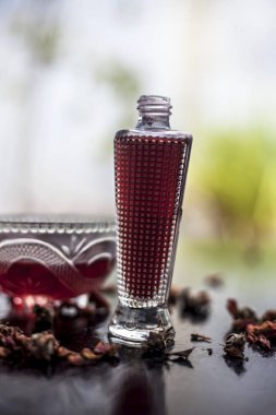Bazı taze limon ve birlikte bir şişe gül suyu ile birlikte ahşap yüzey üzerinde bir cam kase gül su & limon suyu yüz maskesi, akne ve sivilce tedavisi Için.