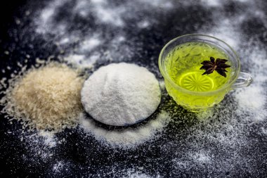 Pirinç un ve pirinç tahıl şeffaf bir cam fincan ve içinde bir Yıldız anason bazı yeşil çay ile birlikte ahşap yüzey üzerinde. Pürüzsüz cilt için tedavi için yüz maskesi.