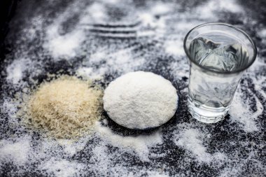 Pirinç suyu, pirinç taneleri ve tozu ile birlikte ahşap yüzey ve bazı pirinç enerjisi gibi çeşitli şeylerin tedavisi için yüzeye yayılmış bir cam kase içinde Rice su ev Remedy, güzellik ve sağlık.