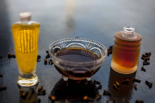 Face mask of clove oil on wooden surface consisting of clove oil and olive oil for the treatment of cleaning dirt and black heads from the skin.