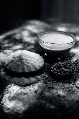 Pirinç un su ve fenugreek/kişniş/maydanoz tohumları toz ahşap yüzey ve bazı pirinç un yüzeyine yayılmış bir cam kase içinde hamur üzerinde saç büyüme çare. Dikey çekim.