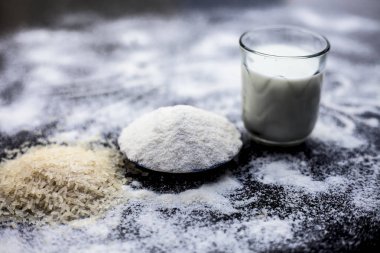 Ahşap yüzeyde anında beyaz cilt için yüz maskesi yani pirinç unu iyi bir cam kase çiğ süt ile karıştırılır. Bazı pirinç unu yüzeye yayıldı. Yatay çekim.