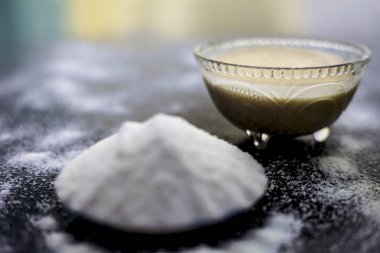 Pirinç un ve pirinç tahıl şeffaf bir cam fincan ve içinde bir Yıldız anason bazı yeşil çay ile birlikte ahşap yüzey üzerinde. Pürüzsüz cilt için tedavi için yüz maskesi.