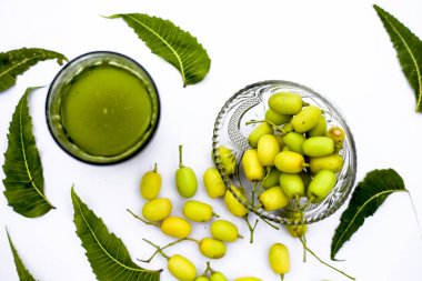 Detoks veya bir cam kase bazı neem meyve veya nimbudi ile birlikte beyaz izole bir bardak neem meyve detoks içki. Yatay atış.