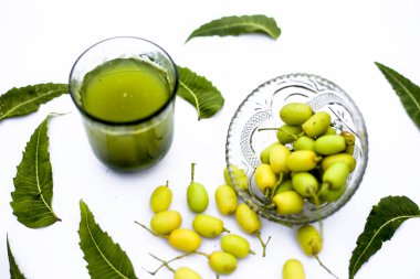 Detoks veya bir cam kase bazı neem meyve veya nimbudi ile birlikte beyaz izole bir bardak neem meyve detoks içki. Yatay atış.