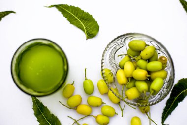 Detoks veya bir cam kase bazı neem meyve veya nimbudi ile birlikte beyaz izole bir bardak neem meyve detoks içki. Yatay atış.