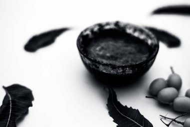 Neem macunu veya nim macunu başka bir kapta neem meyve ile birlikte beyaz izole bir cam kase ve bazı yaprakları da.