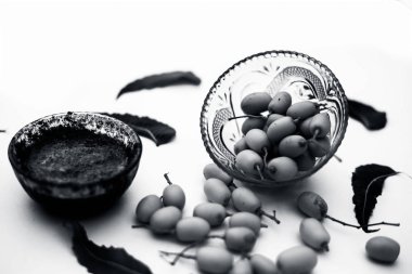 Neem macunu veya nim macunu başka bir kapta neem meyve ile birlikte beyaz izole bir cam kase ve bazı yaprakları da.