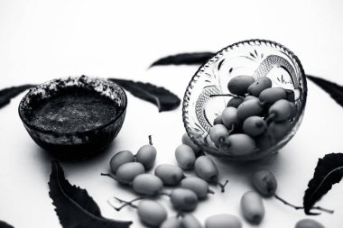 Neem macunu veya nim macunu başka bir kapta neem meyve ile birlikte beyaz izole bir cam kase ve bazı yaprakları da.