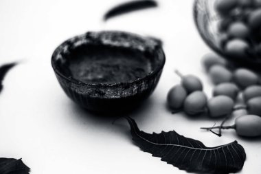 Neem macunu veya nim macunu başka bir kapta neem meyve ile birlikte beyaz izole bir cam kase ve bazı yaprakları da.