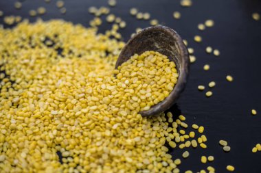 Siyah ahşap yüzeyüzerinde siyah kil kase unskinned bölünmüş mung fasulye 