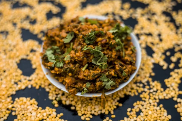 Koyu yüzeyde plaka ıspanak ile kavrulmuş dal Ünlü Hint Punjabi çanak 