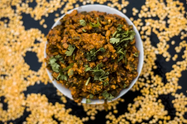 Koyu yüzeyde plaka ıspanak ile kavrulmuş dal Ünlü Hint Punjabi çanak 