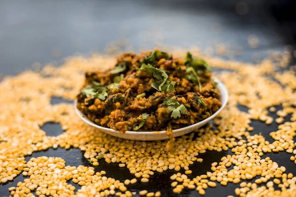 Koyu yüzeyde plaka ıspanak ile kavrulmuş dal Ünlü Hint Punjabi çanak 