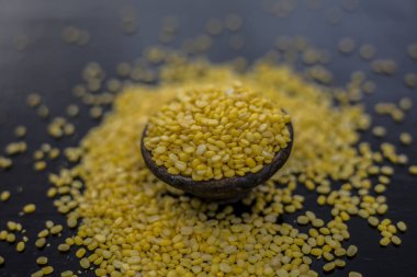 Siyah ahşap yüzeyüzerinde siyah kil kase unskinned bölünmüş mung fasulye 