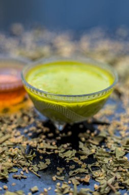 neem yaprakları ile gözlük hazırlık anti-aging faydaları hint leylak yüz maskesi için siyah ahşap yüzey üzerinde macun ve bal bırakır  