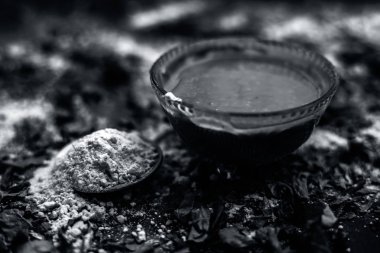 siyah ahşap yüzeyde oluşan akne ve izleri için hint leylak yüz maskesi hazırlık için lor ile gram un ve neem macunu ile kase 