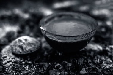 siyah ahşap yüzeyde oluşan akne ve izleri için hint leylak yüz maskesi hazırlık için lor ile gram un ve neem macunu ile kase 